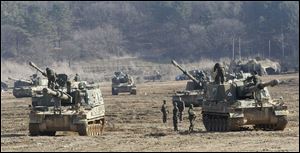 South Korean Army soldiers work on their K-9 self-propelled artillery vehicles during an exercise against possible attacks by North Korea near the border village of Panmunjom in Paju, South Korea, today.