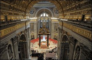 Cardinals, in red, and other prelates and faithful attend a Mass for the election of a new pope celebrated by Cardinal Angelo Sodano, inside St. Peter's Basilica, at the Vatican.