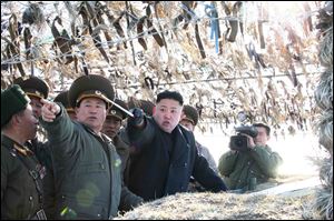North Korean leader Kim Jong Un, third left, looks at South's western border island of Baengnyeong during his visit to the Wolnae Islet Defense Detachment, North Korea, Monday.