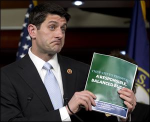 House Budget Committee Chairman Rep. Paul Ryan (R., Wis.), holds up a copy of the 2014 Budget Resolution as he speaks during a news conference on Capitol Hill Tuesday.