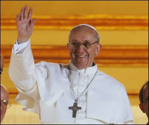 Pope Francis waves to the crowd from the central balcony of St. Peter's Basilica today at the Vatican.