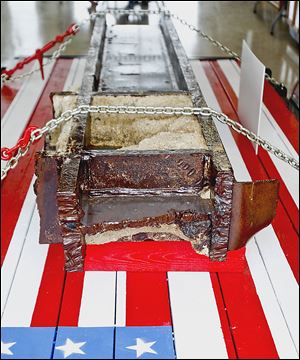 A former World Trade Center beam rested on a flag painted on a vehicle at the Fulton County Fair in 2011. The beam will be part of  the permanent memorial.  Ground breaking is on April 12.
