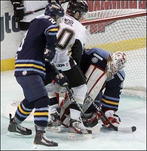 Walleye goalie Kent Simpson is rushed by the Nailers' Tyler Pilmore after a shot during Sunday’s game at the Huntington Center. Wheeling only had 18 shots on goal yet won the game 3-2.