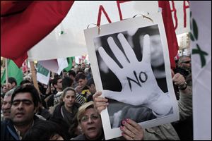 Protesters chant slogans outside the Cypriot parliament against a crucial parliamentary vote on a plan to seize a part of depositors' bank savings, in central Nicosia.
