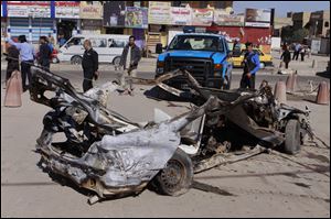 Iraqi security forces inspect the scene of a car bomb attack in the Shiite stronghold of Sadr City, Baghdad, Iraq.