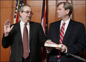 Anthony DeGidio  left, is sworn in as a member of the Lucas County Board of Elections at One Government Center in Toledo, by Toledo Municipal Court Judge Bill Connelly.