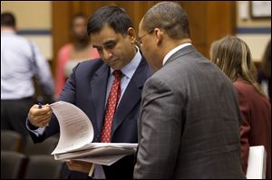 Deputy Commerce Secretary for Resource Management Hari Sastry, left, looks over documents on Capitol Hill in Washington during a break in his testimony in a joint hearing on sequestration.