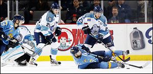 The Walleye's Nino Musitelli, bottom, dives to move the puck against  Evansville's Patrick Kennedy during the second period.