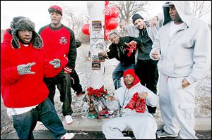 Lawrence Blood Villains members surround a memorial on Hollywood Avenue  for a deceased member in  honor of what would have been his 21st birthday.