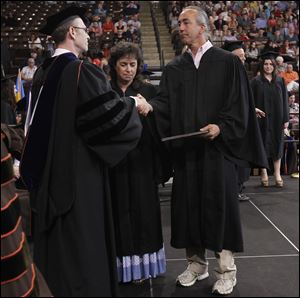 Debbie and Tom Borsz accept their son Mark's diploma during graduation at the BGSU Stroh Center. Mark died in February after collapsing.
