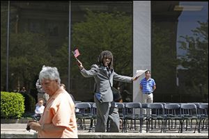Sammy Adebiyi, of West Toledo, center, cheers after receiving his citizenship papers during a Naturalization Ceremony.