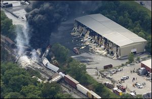 A fire burns at the site of a CSX freight train derailment, Tuesday, in Rosedale, Md.