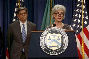 Treasury Secretary Jacob Lew, left, listens at left as Health and Human Services Secretary Kathleen Sebelius speaks about Social Security and Medicare, today, at the Treasury Department in Washington.