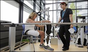 Boston Marathon bombing survivor Roseann Sdoia, of Boston, talks with physical therapist Dara Casparian.