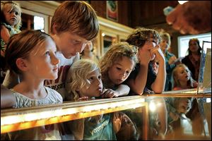 From left, Rosie Kelly, 6, Clyde Kelly, 10, Penny Kelly, 5, and Aubrey Wilhelm, 6, watch the marble-making demonstration. The children were visiting from Spring Lake, Mich. 