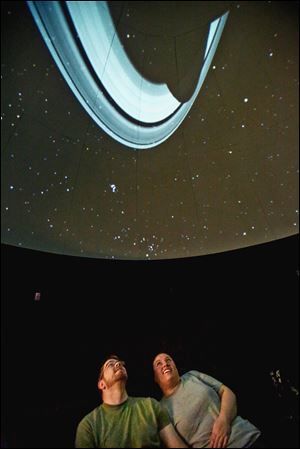Chris McAnall and Sarah Sobel-Poage, both of Perrysburg, view a projection of the rings of Saturn on the dome of the Appold Planetarium at Lourdes University in Sylvania. 