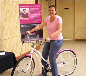 Shari McCague, a breast cancer survivor, sits astride the Komen Race for the Cure themed beach cruiser bicycle that she won in one of the raffle drawings at Confections for the Cure that was held on July 31 at the Toledo Elks Lodge Number 53. 