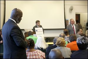 Incumbent Mayor Mike Bell, left, and mayoral candidate D. Michael Collins, right, listen to a comment from a local resident.