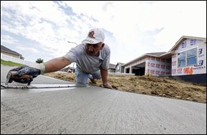 A sidewalk gets shaped in front of new home construction in Omaha, Neb. in August.