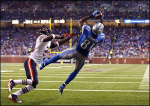 Detroit Lions wide receiver Calvin Johnson (81), defended by Chicago Bears cornerback Charles Tillman (33),  catches a two-yard touchdown from quarterback Matthew Stafford.