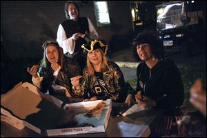 From left, Cleveland residents Jessica and Marco Bruno, Lisa Altschuler, and Wendy Robinson laugh as they talk and eat pizza while dressed as pirates. They visited Put-in-Bay in late September to celebrate Ms. Altschuler's upcoming birthday. 