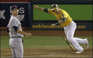 Oakland Athletics' Stephen Vogt, right, celebrates after hitting a single off of Detroit Tigers pitcher Rick Porcello, left, to score Yoenis Cespedes during the ninth inning of Game 2 of an American League Division Series in Oakland, Calif., Saturday, Oct. 5, 2013. The Athletics won 1-0.