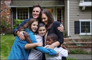 Michael and Jodie Howerton are shown with kids Alex, 13, left, Caleb, 11, and Mduduzi, 8, who is HIV-positive.