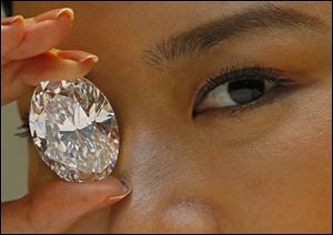 A 118.28-carat white diamond is displayed by a model at a press preview at Sotheby's auction house in Hong Kong. 