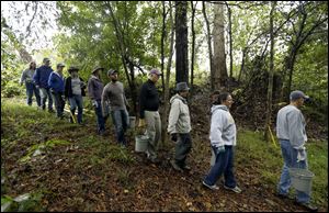 Furloughed employees from the Environmental Protection Agency march into a wooded area to do volunteer trail maintenance on a public canoe access point on the Eno River in Hillsborough, N.C.