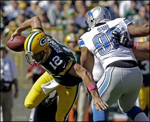 Green Bay Packers quarterback Aaron Rodgers tries to avoid Detroit Lions' Ndamukong Suh during the first half Sunday in Green Bay, Wis.