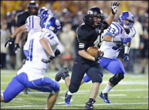 Perrysburg High School player Mark Delas (49) cuts between Anthony Wayne High School players Josh Schwerer (11) and Blake Alberts (33) during the second quarter of their football game Friday night at Perrysburg Junior High School.