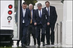 Republican senators, from left, Ted Cruz of Texas, John McCain of Arizona, David Vitter of Louisiana, and Richard Shelby of Alabama, walk in the rain back to their bus at the the White House, Friday, Oct. 11, 2013, after they met with President Barack Obama.