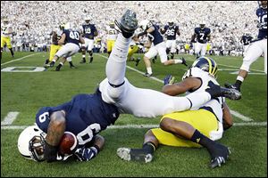 Penn State’s Jordan Lucas, left, falls out of bounds after being tackled by Michigan’s Jeremy Gallon after inter-cepting a pass during the first quarter. 