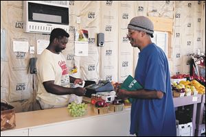 Regular customer Ronnie Bumphis buys grapes, apples and nectarines from David Johnson.