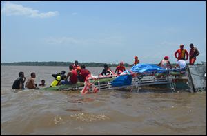 Rescue workers search for survivors in the capsized boat at the Amazon river near Macapa, Brazil. The boat carrying Catholic pilgrims to take part in a festival commemorating Our Lady of Nazare capsized on Brazil's Amazon river, leaving at least 12 people dead and another six still missing.