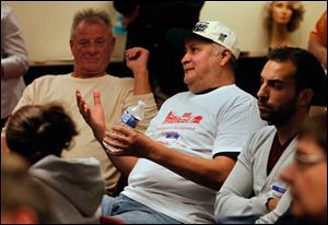 Wayne Ahumada , center, questions mayoral candidate D. Michael Collins.