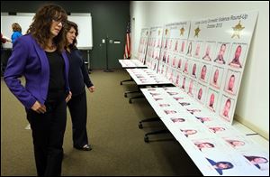 Denise Boyer, coordinator of the Domestic Violence Resource Center at Lucas County Family Court, left, and Lynn Jacquot, director of the Battered Women’s Shelter at the YWCA of Northwest Ohio, view booking photos of alleged domestic violence offenders ahead of Lucas County Sheriff John Tharp’s news conference.