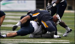 Navy's Cody Peterson yanks back the head of UT's David Fluellen during 2nd half at the University of Toledo Glass Bowl in Toledo, Ohio. Fluellen was taken out of the game injured. No penalty called.