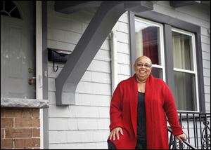 First time buyer Gilda Coleman stands on the porch of her new home.