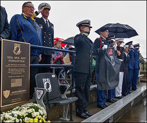 Toledo president Dr. Lloyd Jacobs, left, United States Naval Academy superintendent vice admiral Michael H. Miller, center,  and U.S. Navy Reserve Lt. Haraz Ghanbari dedicate the permanent POW-MIA seat at the Glass Bowl.