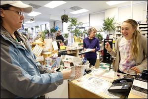 Emily Goodwin, left, brings in her paper to be stamped by Aleka Bassett, right, at the Bassett counter during the 