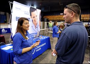 Registered nurse Salanda Bowman, left, talks with part-time Kentucky Wesleyan College student Jason Ward, of Whitesville, about job openings at the Owensboro Health Regional Hospital during a Regional Career and Job Fair in the Owensboro Sports Center  in Owensboro, Ky. earlier this month.