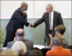 Toledo Mayor Mike Bell, left, and his challenger D. Michael Collins, a city councilman, shake hands after speaking at Cleaner & Dryer Restoration.