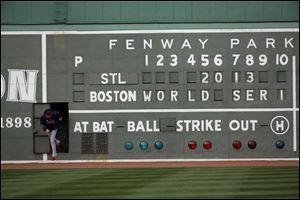 St. Louis Cardinals' Michael Wacha runs out of a scoreboard under the Green Monster before batting practice for Game 1 of baseball's World Series against the Boston Red Sox.