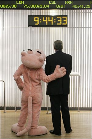 David Brown, president and CEO of Owens Corning, and the Pink Panther watched a stock ticker on the floor of the New York Stock Exchange on Nov. 11, 2006, after the building-materials maker, just out of Chapter 11 bankruptcy, began trading again on the exchange after a four-year absence.