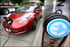 A Nissan Leaf charges at an electric-vehicle charging station in Portland, Ore. The governors of eight states, including California and New York, pledged Thursday to get 3.3 million zero-emission vehicles on roadways by 2025 in an effort to curb greenhouse gas pollution.