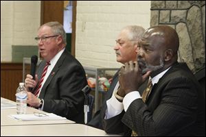  Toledo mayoral candidate D. Michael Collins, left, John Szozda, moderator of the debate and general manager of the Press, one of the event sponsors, center, and Toledo Mayor Mike Bell appear at a forum at the East Toledo Senior Center.