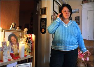 Blanca Romero talks on the phone Friday with Toledo police Sgt. Tim Noble about  the hunt for Marquis Walker, who is wanted in the death of Jordan Jones-Harris, 23, Ms. Romero’s stepdaughter.