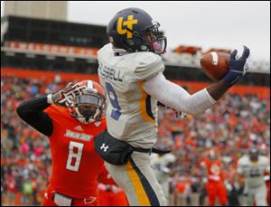 University of Toledo player Alonzo Russell (9) makes a one-handed catch for a touchdown over Bowling Green State University player Cameron Truss (8) during the second quarter.