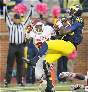 Michigan quarterback Devin Gardner takes a big hit from Indiana's Tim Bennett after scoring a touchdown during their Oct. 19 game in Ann Arbor. Bennett was flagged for a personal foul on the play.